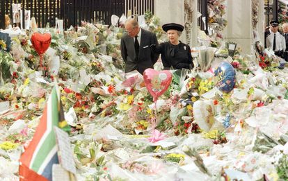 La Reina Isabel II y su esposo, Felipe de Edimburgo, observan los miles de ramos de flores depositados por ciudadanos en el exterior del Palacio de Buckingham, en memoria de Diana de Gales, fallecida en accidente de tráfico, en una imagen del 5 de septiembre de 1997.