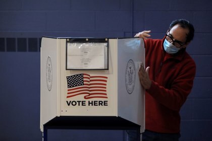Un hombre desinfecta una maquina para la votación anticipada en Nueva York (REUTERS/Andrew Kelly)