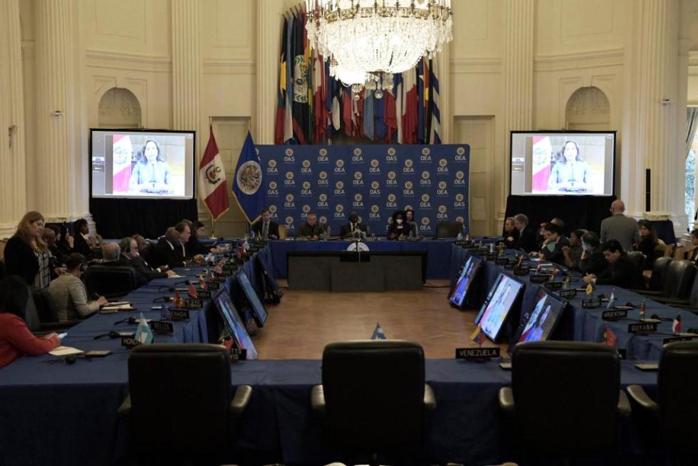 La presidenta peruana, Dina Boluarte (en pantalla), habla durante una intervención virtual ante el Consejo Permanente de la Organización de Estados Americanos (OEA), hoy en la sede del organismo en Washington (EE. UU). Boluarte instó este miércoles a los "países amigos" a que apoyen la propuesta para adelantar la elecciones y lograr una salida "pacífica" a la crisis en la que se haya inmerso Perú. EFE/Lenin Nolly
